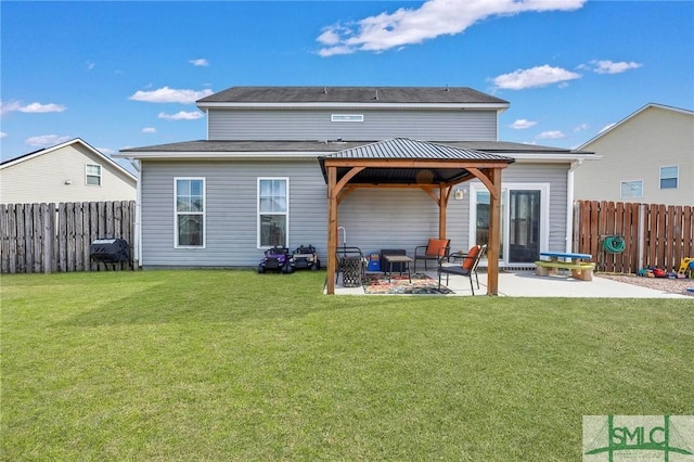 rear view of property featuring a lawn, a gazebo, and a patio area