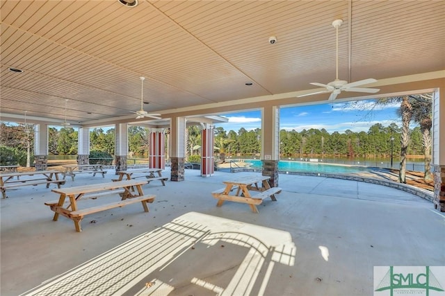 view of patio / terrace with ceiling fan, a fenced in pool, and a water view