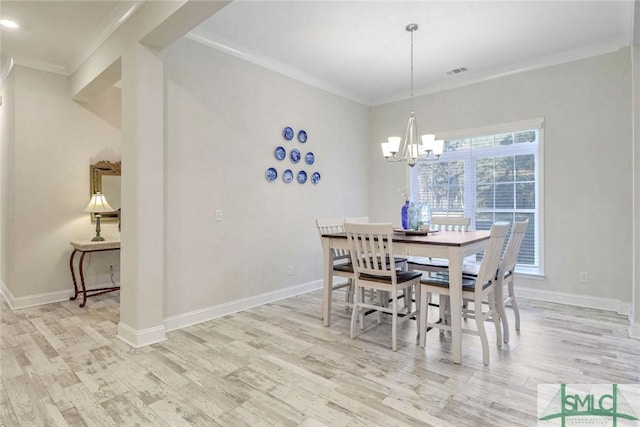 dining space with light hardwood / wood-style floors, an inviting chandelier, and crown molding