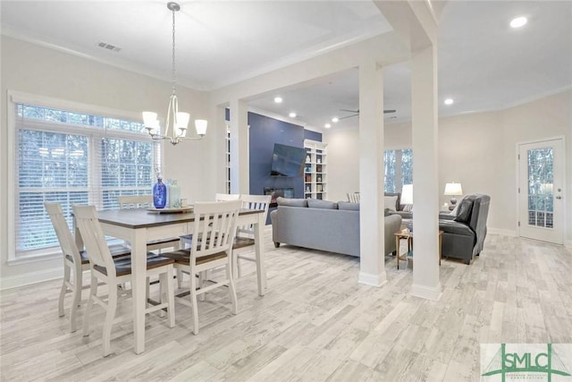 dining space with ornamental molding, light wood-type flooring, and plenty of natural light