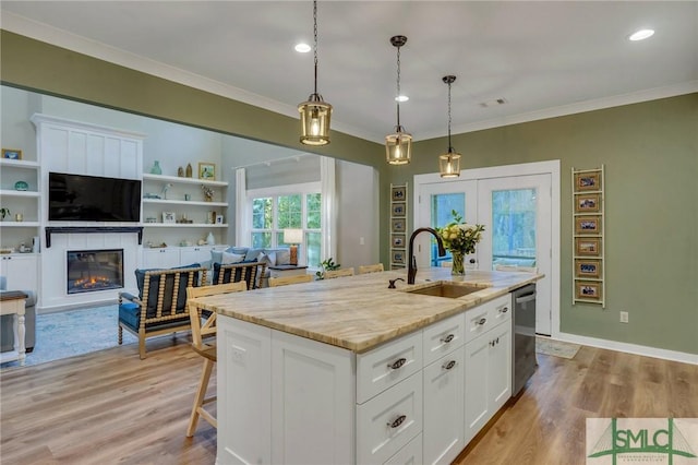 kitchen featuring dishwasher, crown molding, white cabinets, and a sink