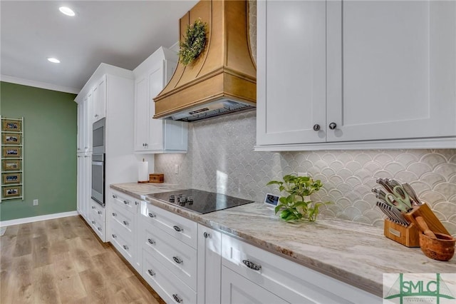 kitchen featuring premium range hood, oven, white cabinetry, black electric stovetop, and light stone countertops