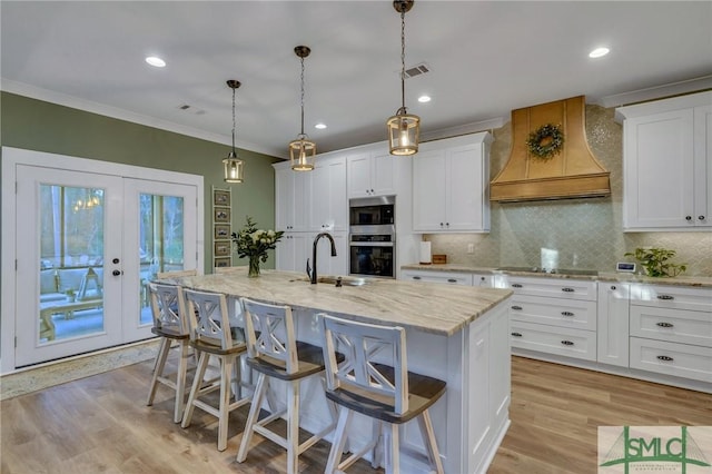 kitchen with custom exhaust hood, a sink, stainless steel appliances, french doors, and crown molding