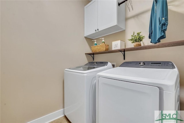 washroom featuring cabinet space, baseboards, and separate washer and dryer