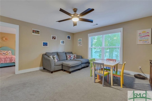 carpeted living room with visible vents, baseboards, and a ceiling fan