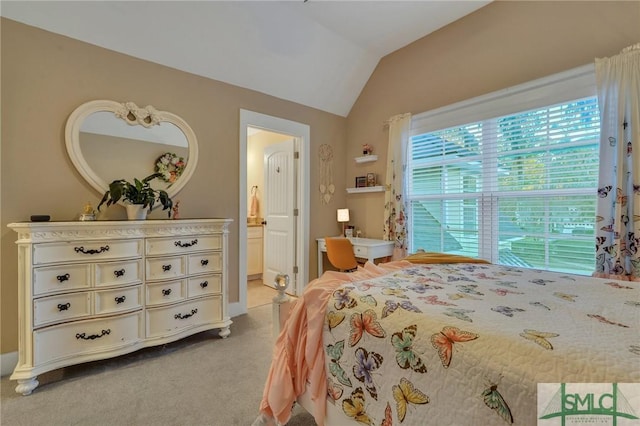 bedroom featuring ensuite bath, lofted ceiling, and carpet floors