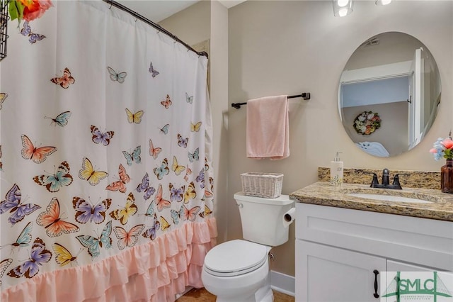 bathroom with curtained shower, toilet, and vanity