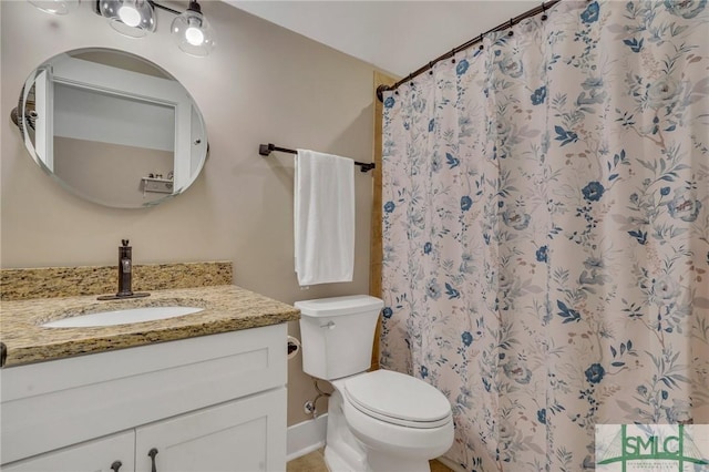 bathroom with vanity, curtained shower, and toilet