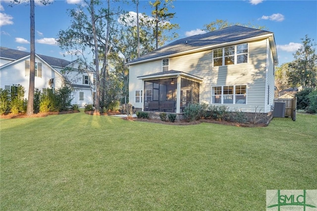 rear view of property with a lawn and a sunroom