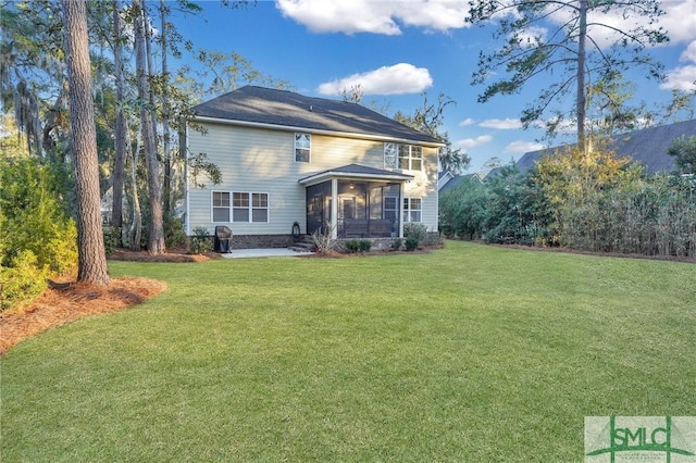 rear view of property with a yard and a sunroom