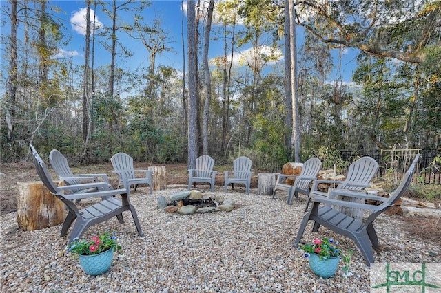 view of yard featuring a patio area, a fire pit, and fence