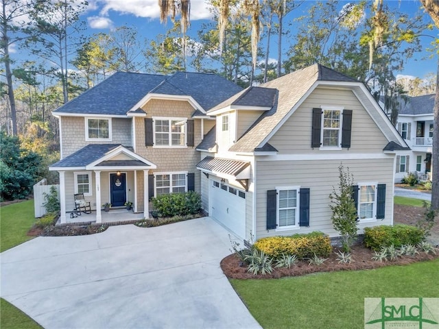 view of front of home featuring a porch, a front yard, driveway, and a garage