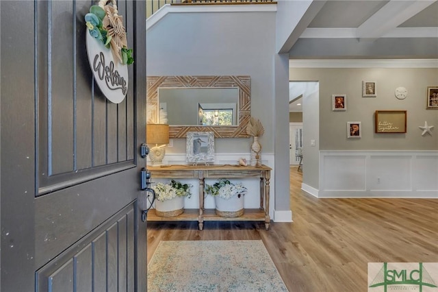 entryway with hardwood / wood-style flooring and crown molding