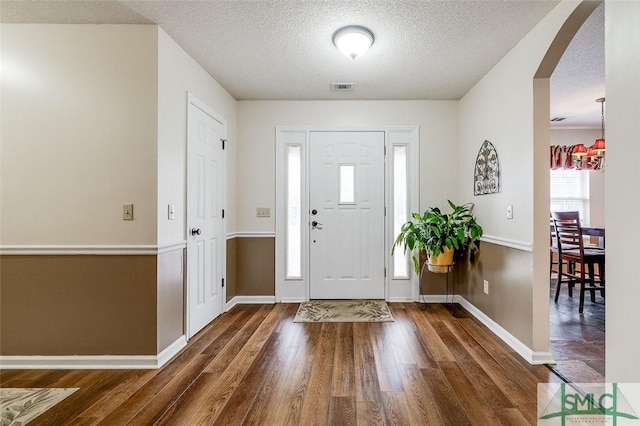 entryway featuring a textured ceiling and dark hardwood / wood-style flooring