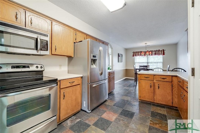 kitchen with kitchen peninsula, stainless steel appliances, a textured ceiling, and pendant lighting