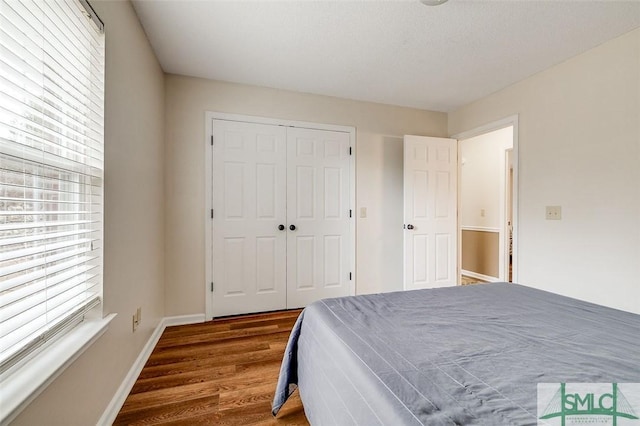 bedroom with dark wood-type flooring and a closet