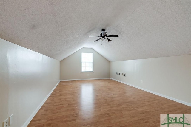 additional living space featuring lofted ceiling, ceiling fan, and light hardwood / wood-style flooring