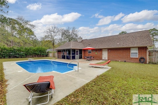 view of pool featuring a lawn, a diving board, a sunroom, and a patio