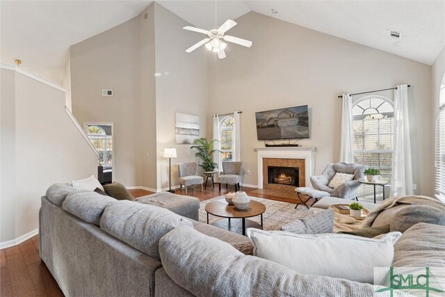 living room featuring dark wood-type flooring, high vaulted ceiling, and ceiling fan