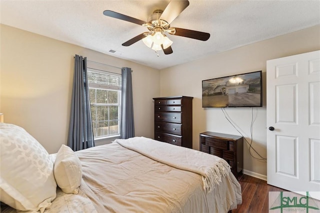 bedroom featuring a textured ceiling, ceiling fan, and dark hardwood / wood-style floors