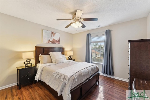 bedroom featuring ceiling fan, dark hardwood / wood-style flooring, and a textured ceiling