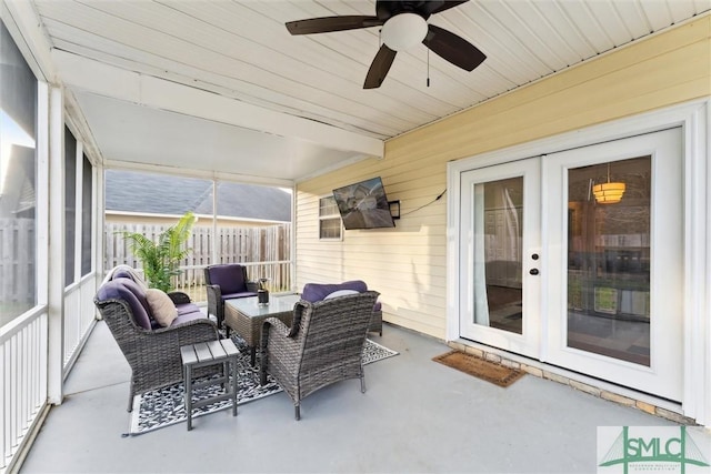 sunroom featuring ceiling fan, beam ceiling, and french doors