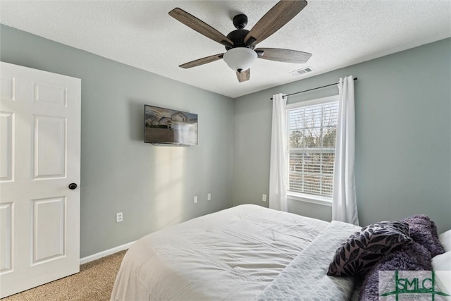 carpeted bedroom with a textured ceiling and ceiling fan