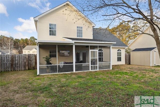 rear view of property with a sunroom, a lawn, and a storage unit