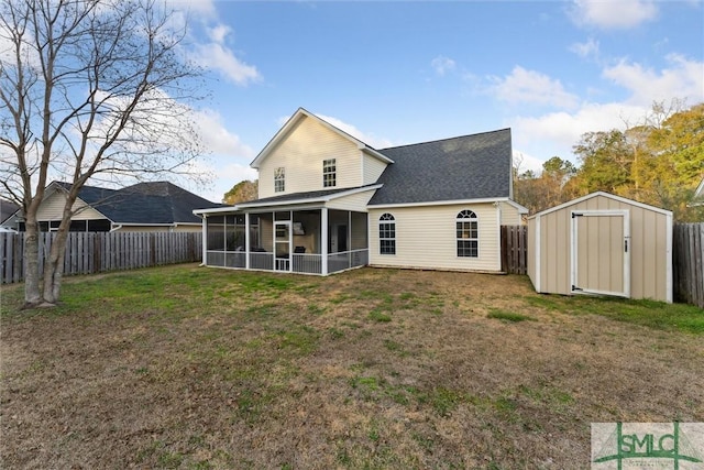 rear view of house with a sunroom, a storage shed, and a yard