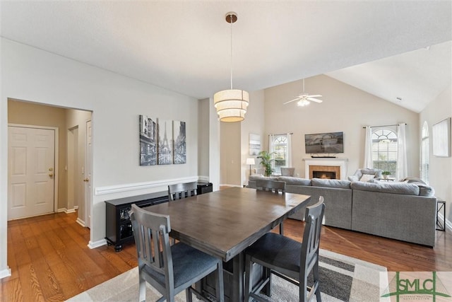 dining area with vaulted ceiling, ceiling fan, and wood-type flooring