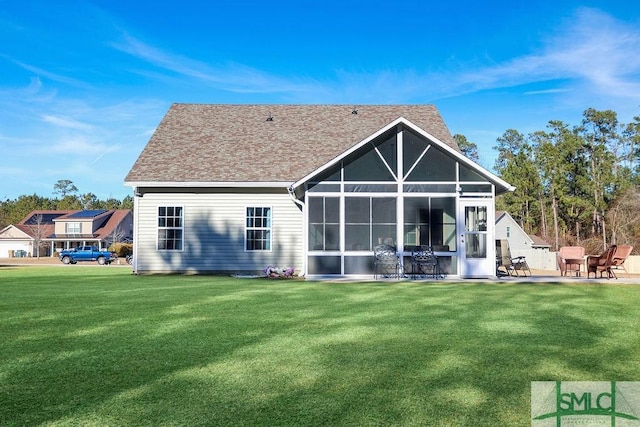 back of property with a lawn, a patio area, and a sunroom