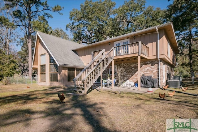 back of house featuring a wooden deck, central AC unit, and a lawn