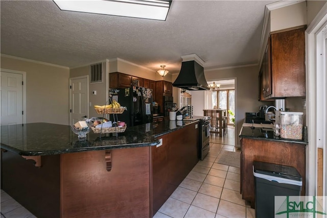 kitchen featuring light tile patterned floors, island range hood, electric range, black fridge, and a textured ceiling