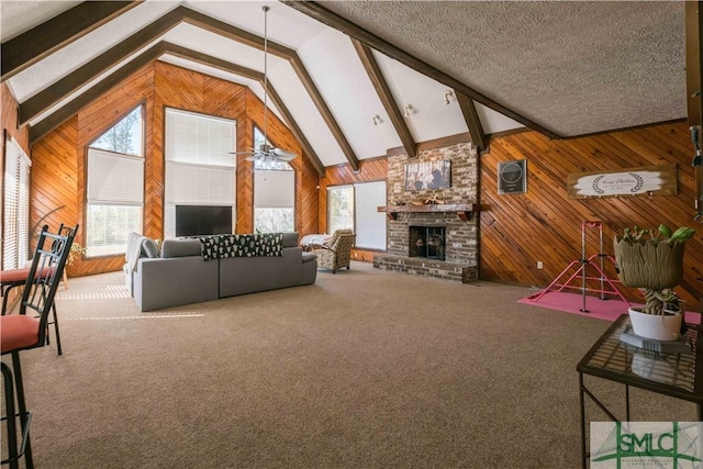 unfurnished living room with beam ceiling, carpet, a fireplace, and a textured ceiling