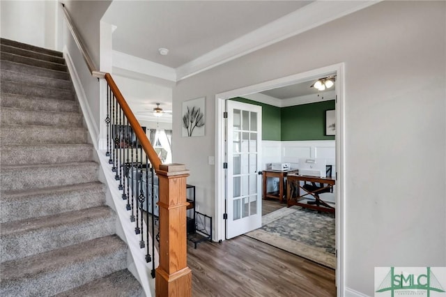 stairs with ceiling fan, crown molding, french doors, and hardwood / wood-style floors