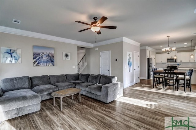 living room featuring ceiling fan, dark wood-type flooring, and ornamental molding