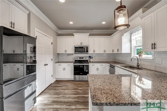 kitchen featuring sink, stainless steel appliances, pendant lighting, and white cabinets