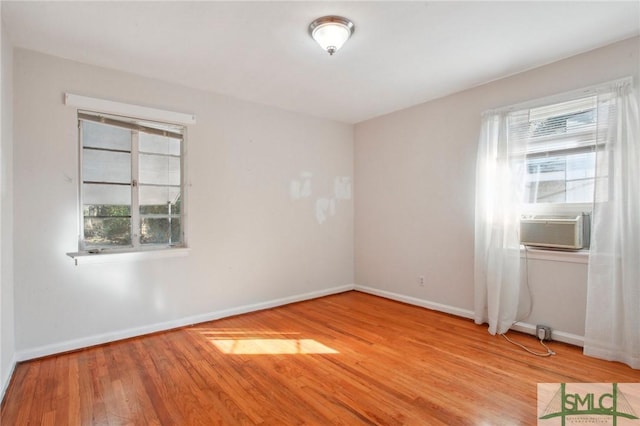 empty room featuring cooling unit and light hardwood / wood-style floors