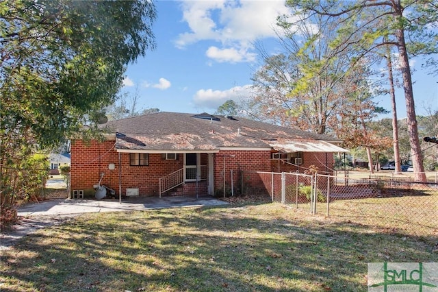 back of house featuring a patio area and a lawn