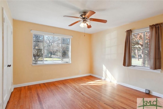 empty room with ceiling fan, a healthy amount of sunlight, and light hardwood / wood-style flooring