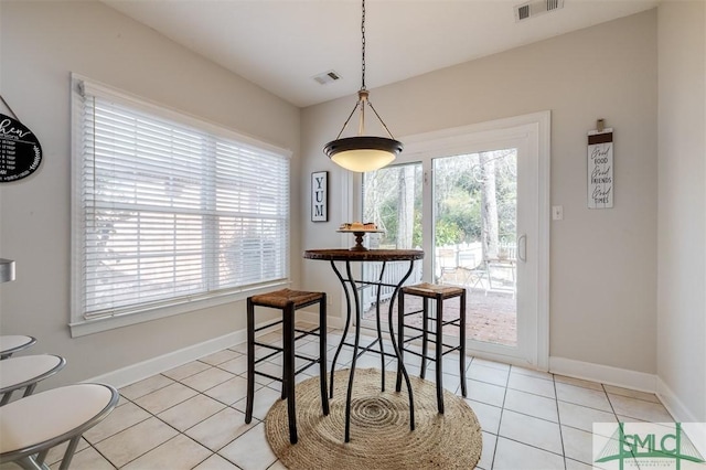 dining room featuring light tile patterned floors, visible vents, and a healthy amount of sunlight