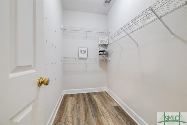 spacious closet featuring visible vents and wood finished floors