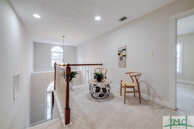 sitting room with recessed lighting, light carpet, visible vents, and baseboards