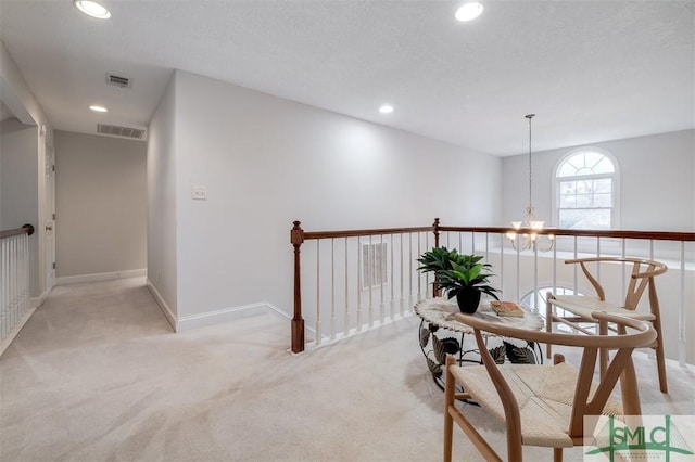 corridor with a chandelier, recessed lighting, visible vents, and light colored carpet