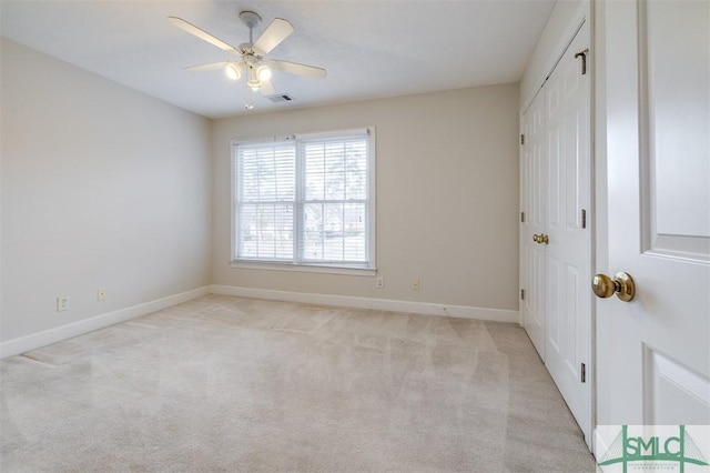 unfurnished bedroom with a ceiling fan, baseboards, a closet, and light colored carpet