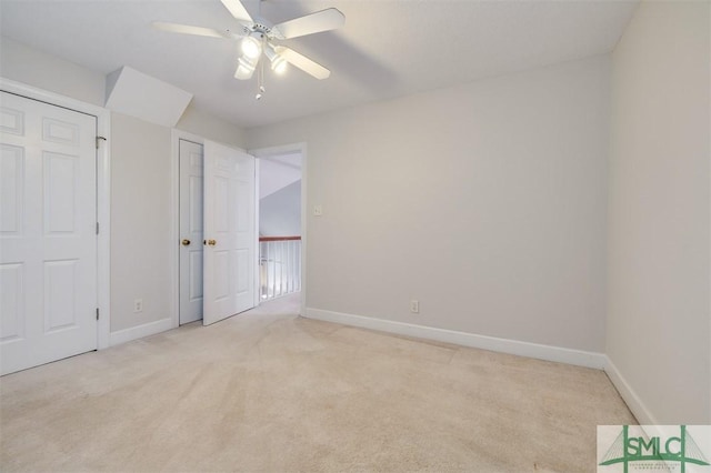 unfurnished bedroom with light carpet, ceiling fan, and baseboards