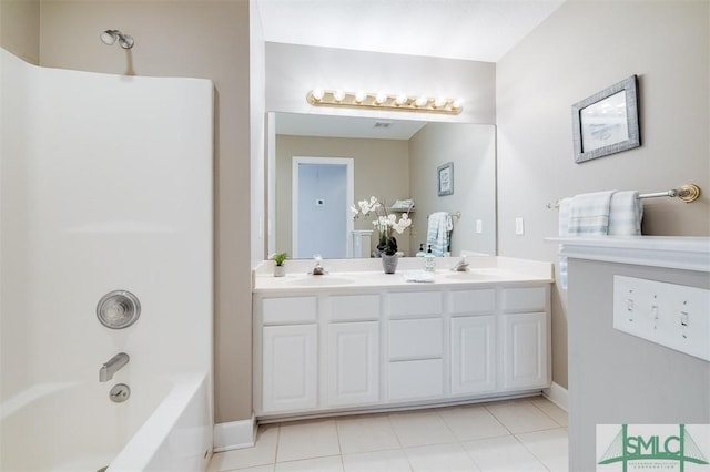 bathroom with double vanity, tile patterned flooring, a sink, and washtub / shower combination