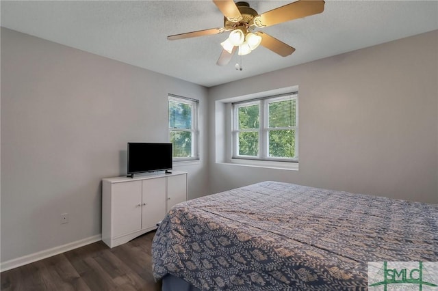 bedroom featuring ceiling fan, dark wood-type flooring, and a textured ceiling