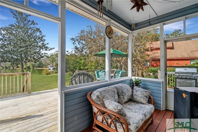 sunroom / solarium with ceiling fan, a water view, and a healthy amount of sunlight