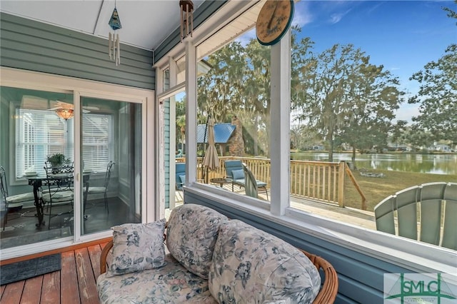 sunroom featuring a water view